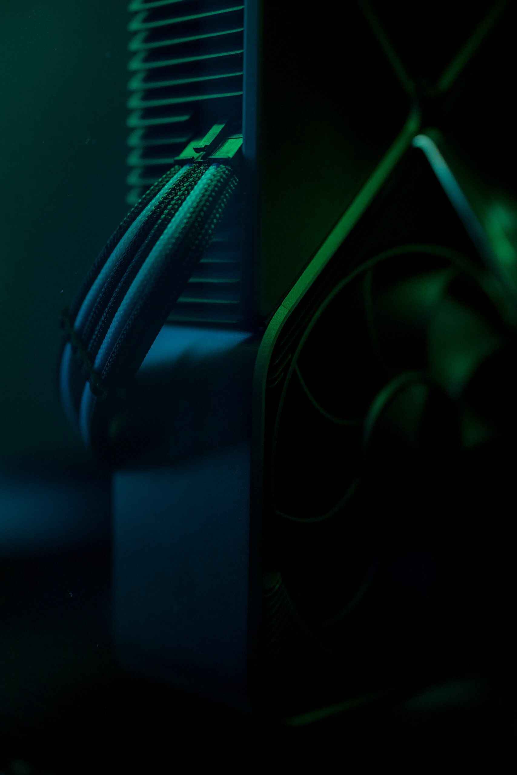 Kilka kabli wpiętych do komputera w przyciemnionym pomieszczeniu, z delikatną zieloną poświatą
