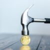 Młotek nad złotą monetą Bitcoina