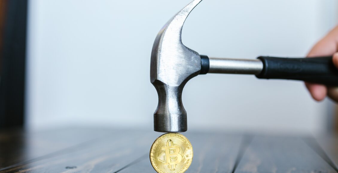 Młotek nad złotą monetą Bitcoina