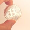 Złota moneta Bitcoina trzymana w ręce