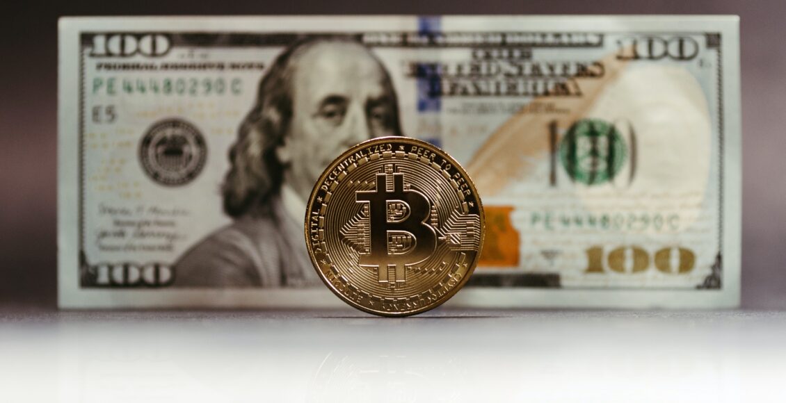Zdjęcie monety Bitcoina na tle dolara amerykańskiego
