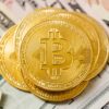 Złote monety BTC na tle banknotów dolarów