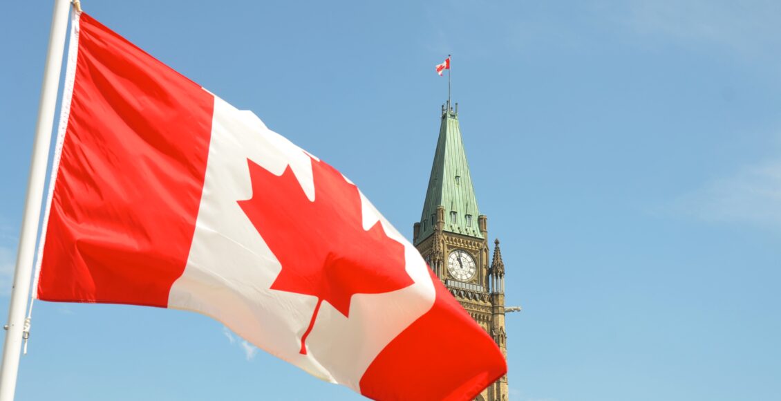 Zdjęcie kanadyjskiej flagi na tle ratuszu w Quebecu