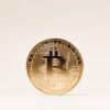 Zdjęcie złotej monety Bitcoina na jasnym tle