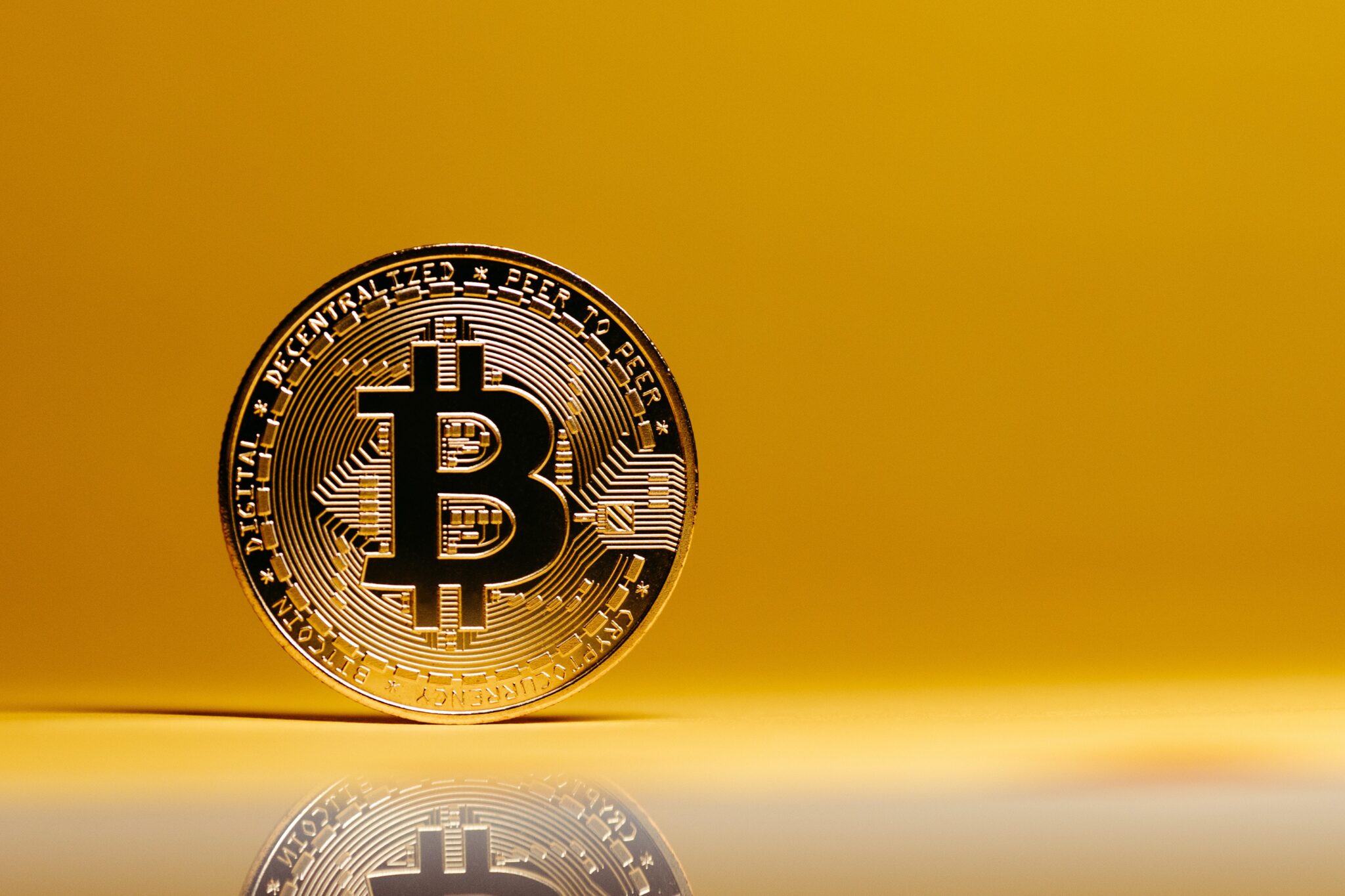 Złota moneta Bitcoin, na złotym tle