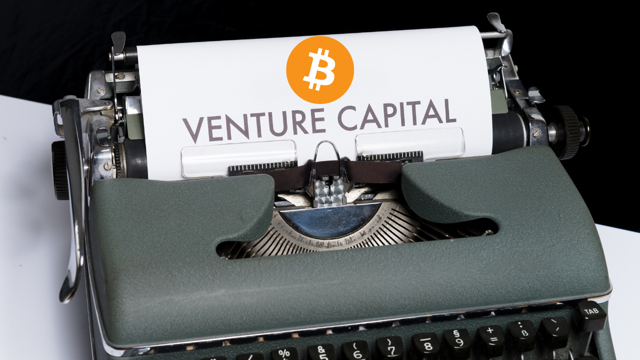 maszyna do pisania z kartką z napisem venture capital i logiem bitcoina