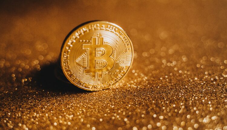Złota moneta BTC na tle złota