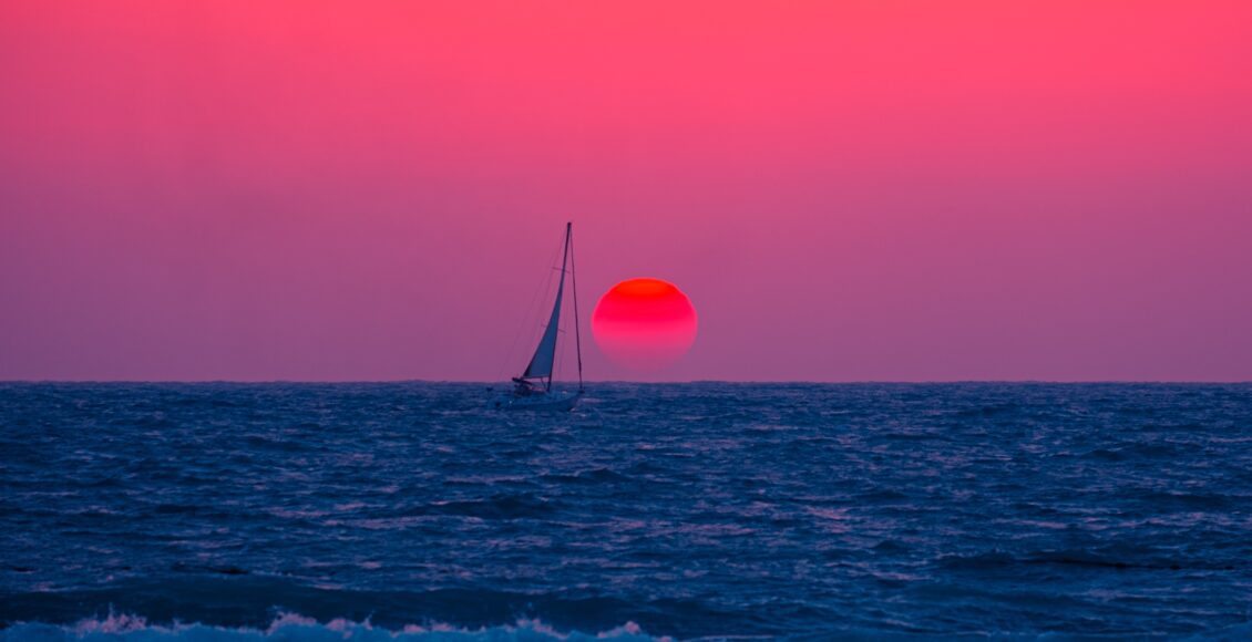 Zdjęcie łodzi na tle zachodzącego słońca