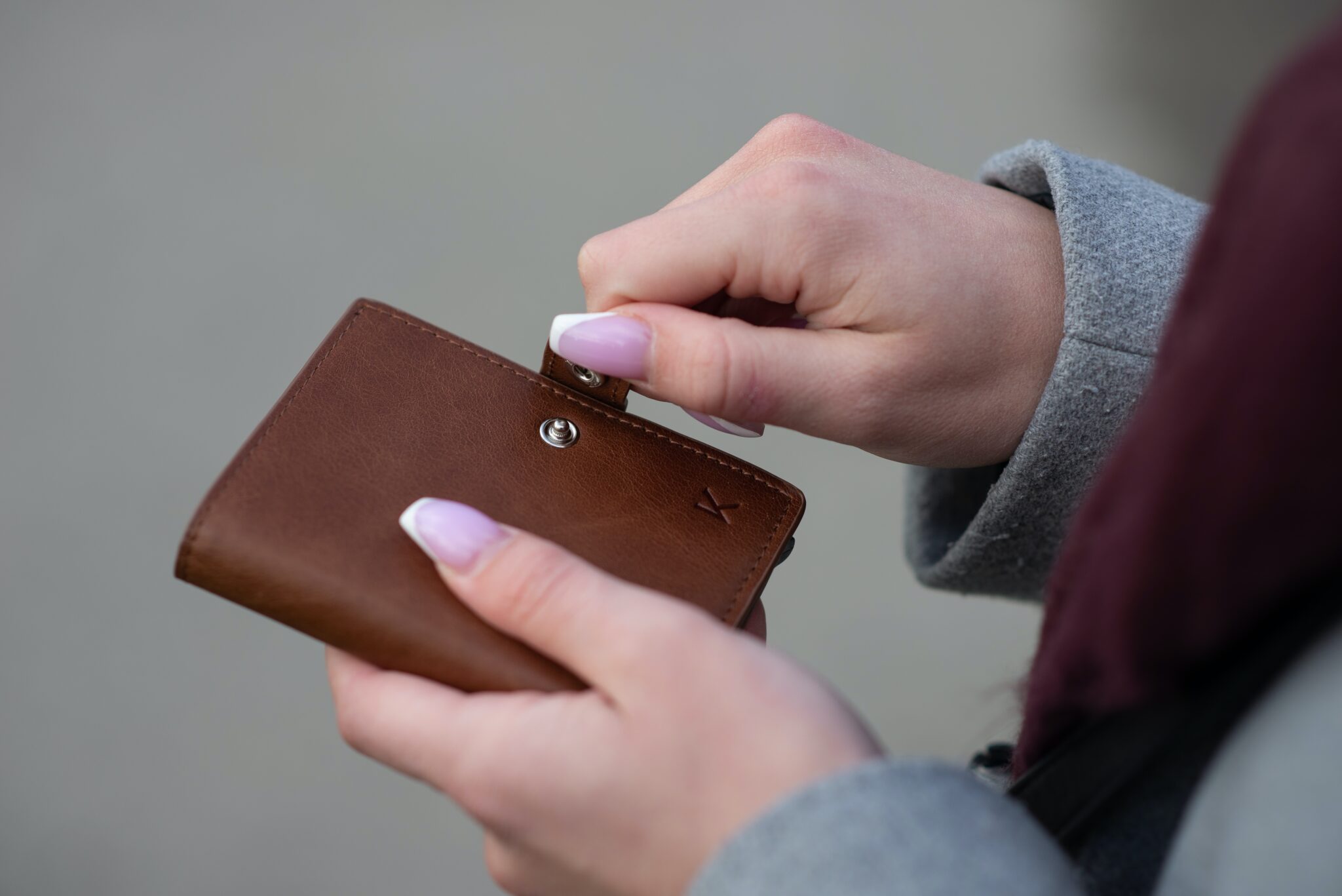 ręce trzymające portfel, w którym trzyma się pieniądze