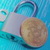 kluczyk z kłódką i bitcoinem na jasnoniebieskim tle