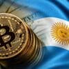 Moneta Bitcoina obok flagi Argentyny