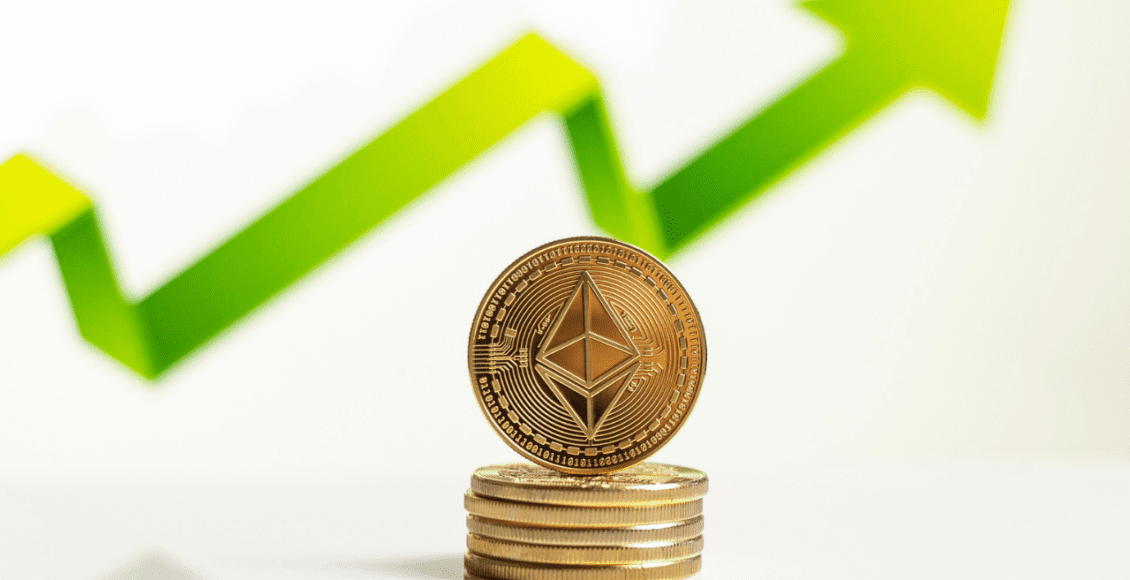 monety z logiem ethereum leżące w stosie, nad nimi zielona strzałka skierowana w górę