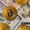 Złote BTC na tle banknotów USD