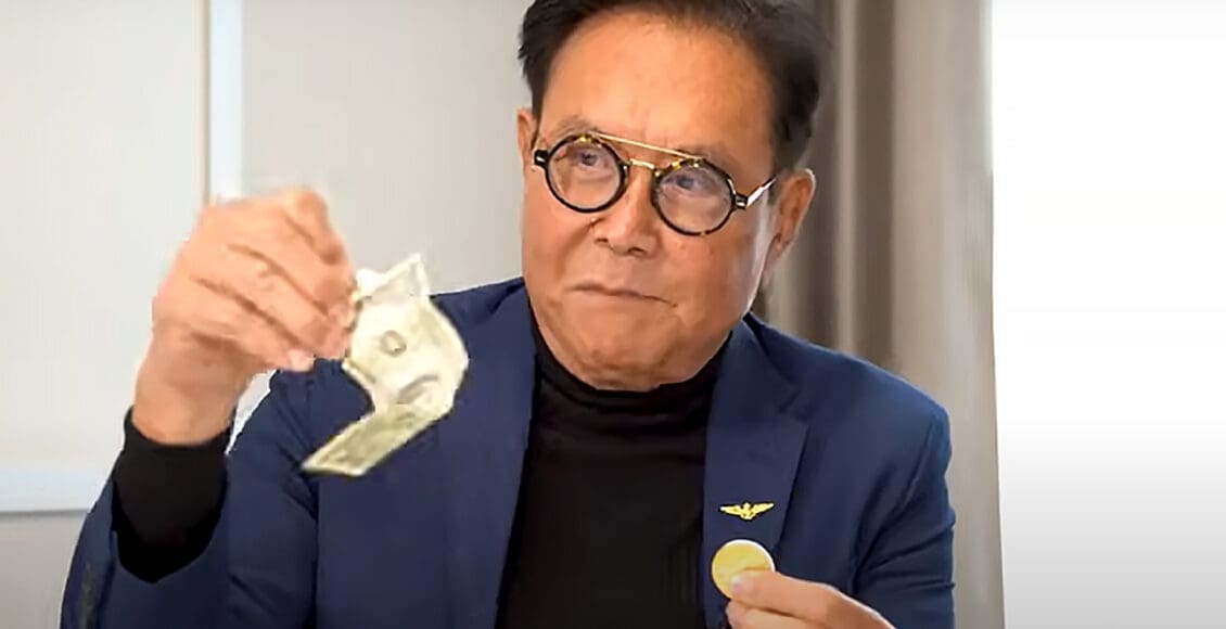 Robert Kiyosaki trzymający dolara i złoto