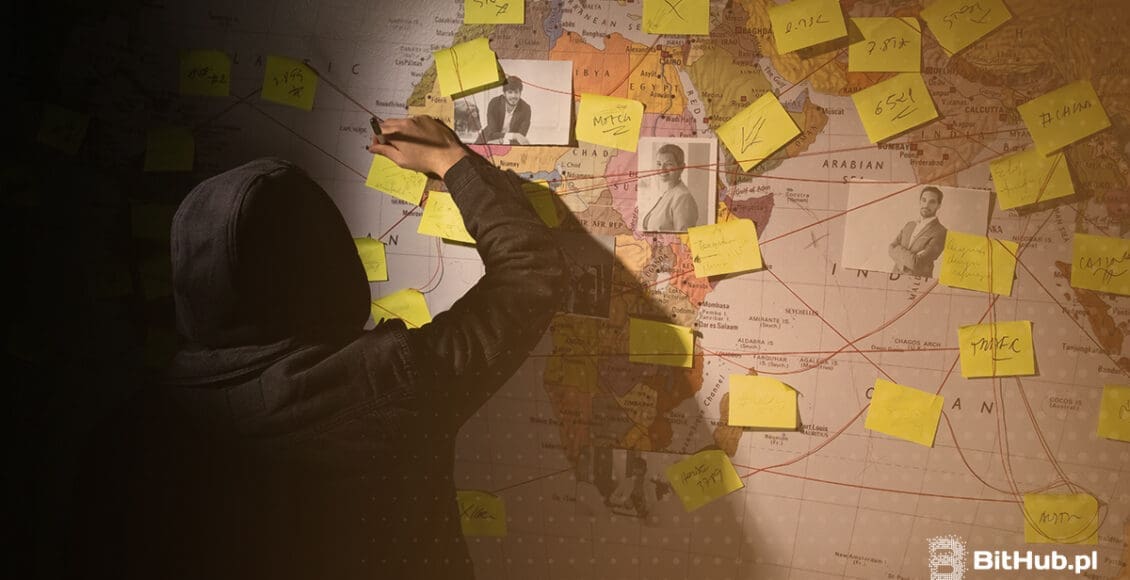 Zakapturzona osoba przypinająca na mapie świata adresy i zdjęcia osób