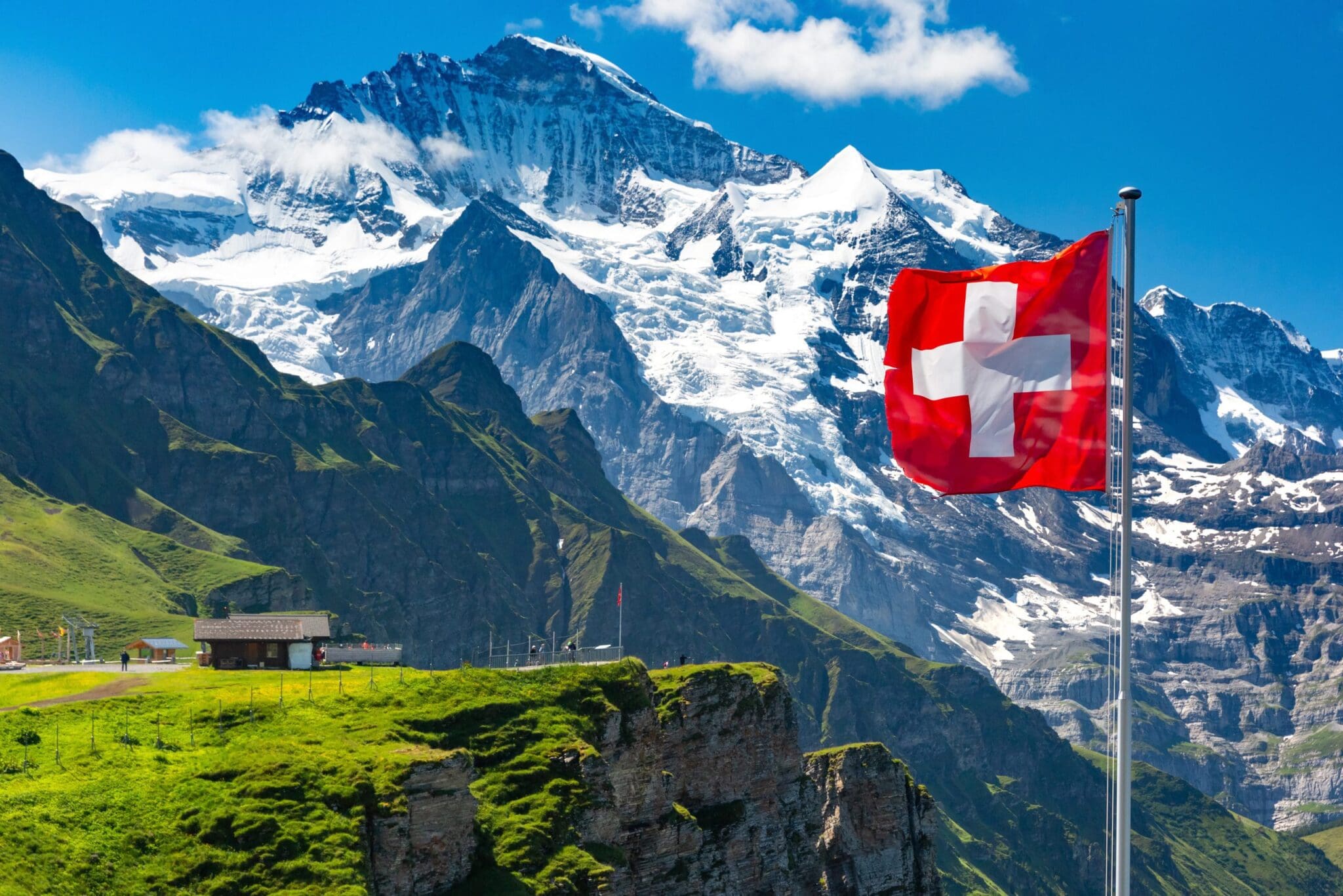 Szwajcarska flaga, z widokiem na Alpy w tle