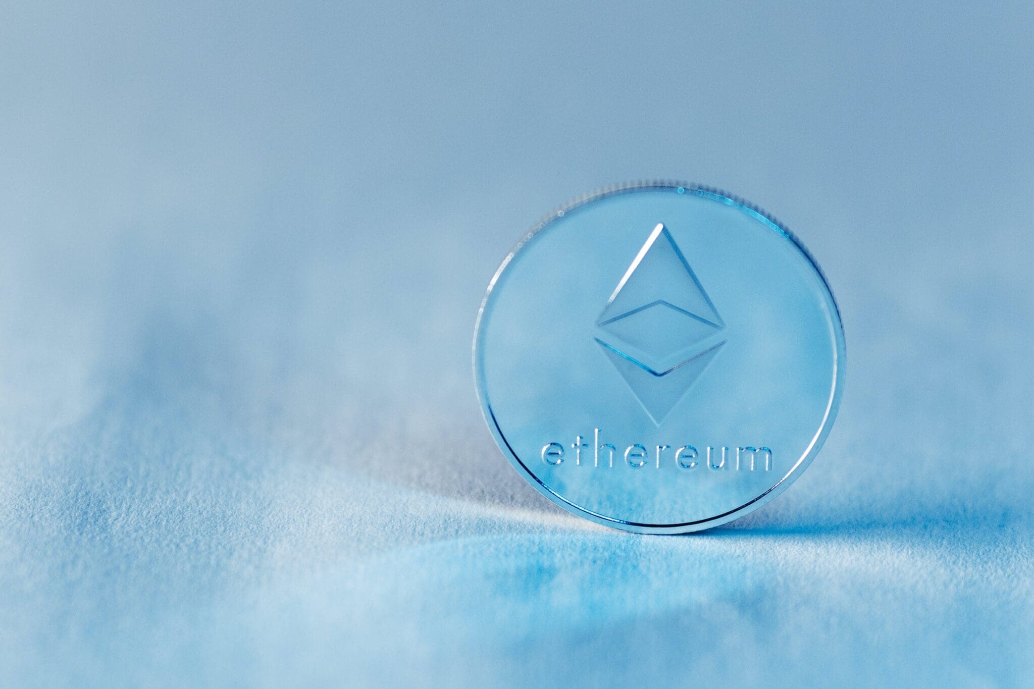 Błękitna moneta z logo Ethereum na białym tle