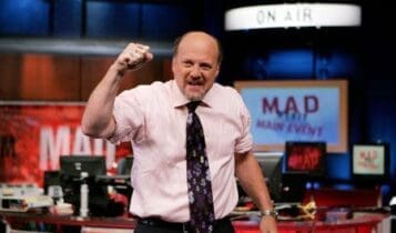 Jim Cramer z ręką uniesioną ku górze i studiem CNBC w tle