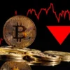 Moneta Bitcoin z czerwonum wykresem w tle