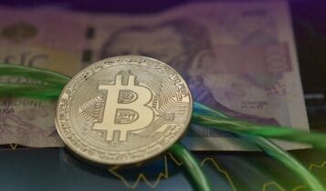 Bitcoin leżący na banknocie papierowym
