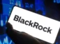 Napis BlackRock na ekranie telefonu, z wykresami w tle