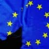 Rozdarta flaga Unii Europejskiej na czarnym tle.