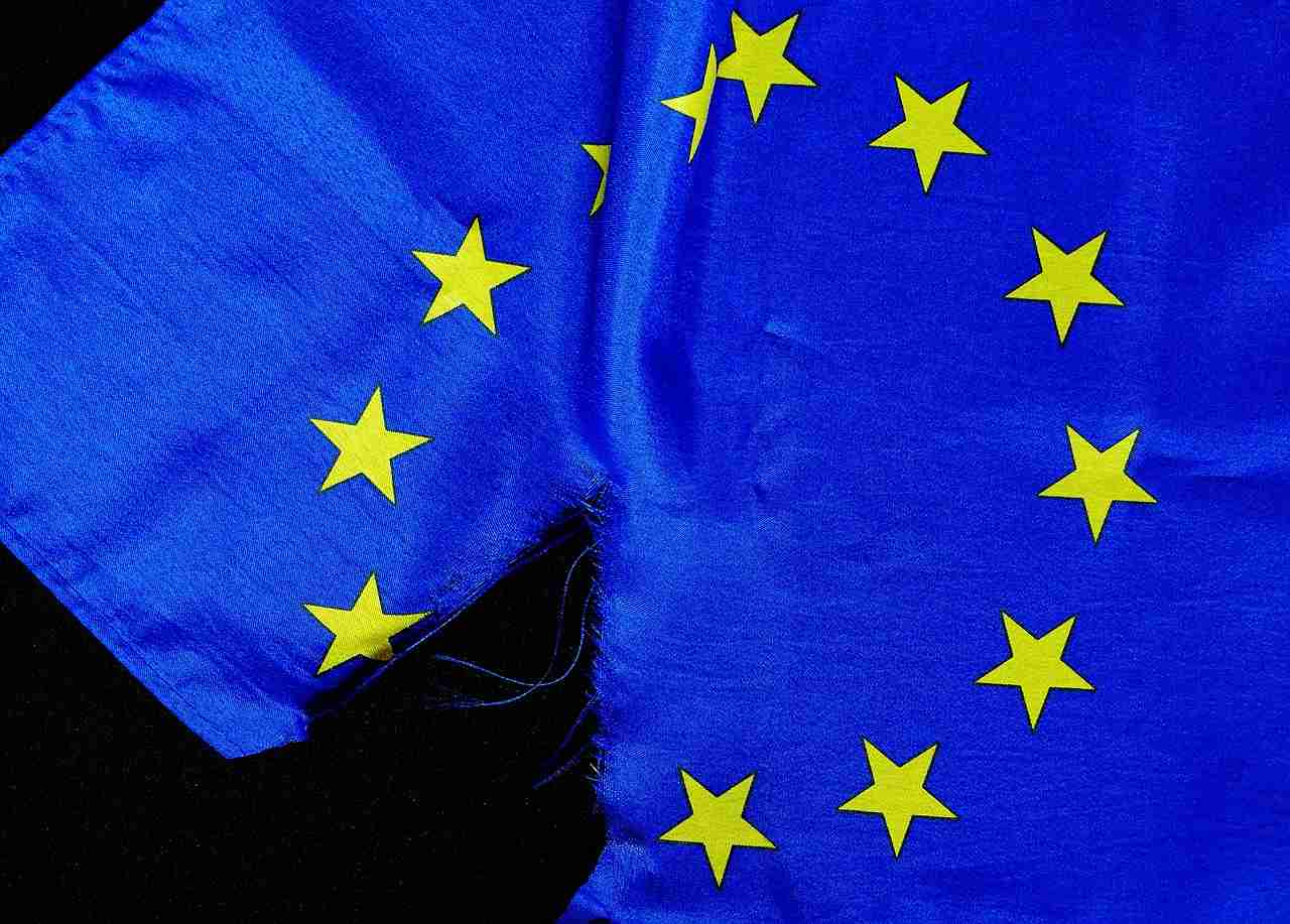 Rozdarta flaga Unii Europejskiej na czarnym tle.