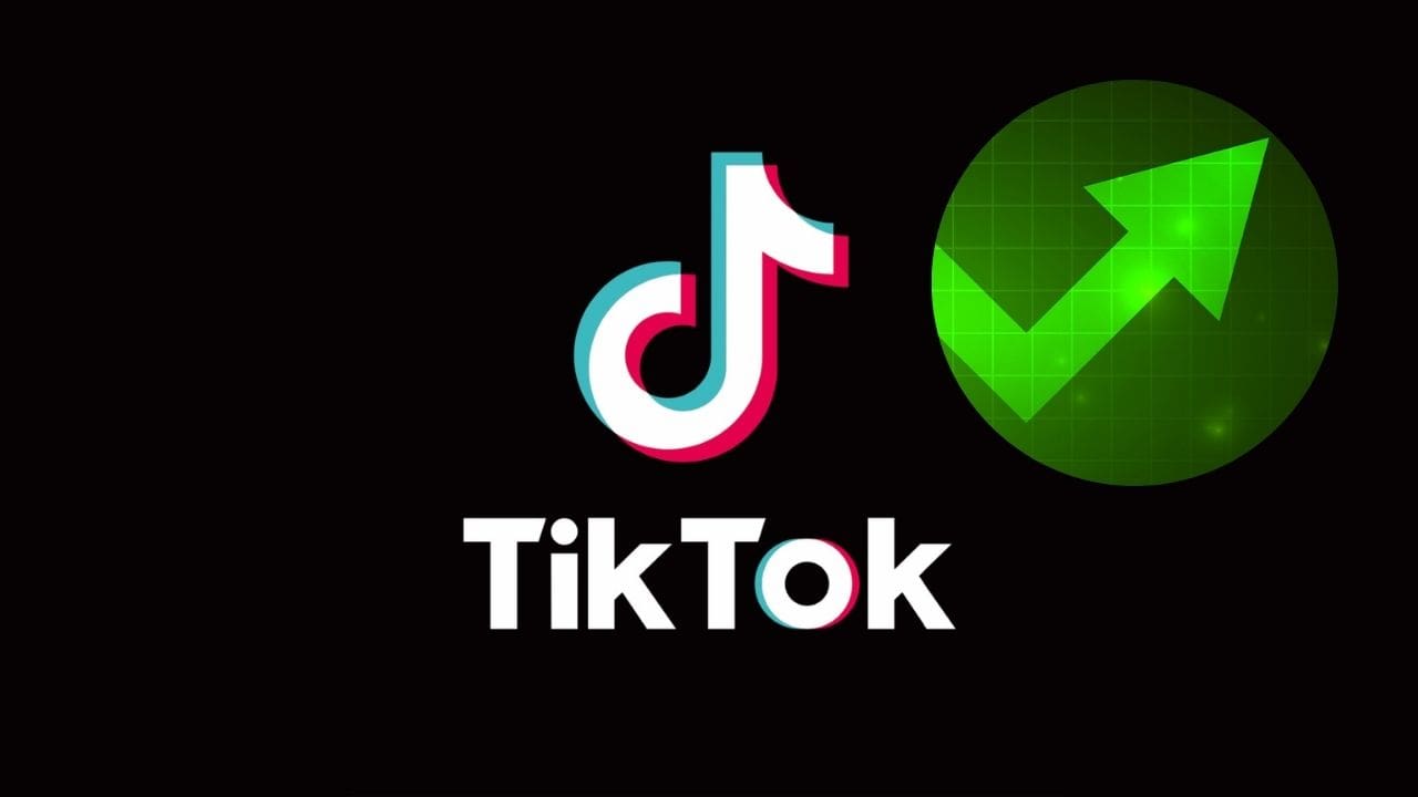 Logo aplikacji TikTok z zieloną strzałą sygnalizującą wzrosty