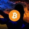 Ciemna postać trzymająca Bitcoina. W tle ciemne, zachmurzone niebo.