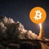 Start rakiety Bitcoin, dym, ciemne niebo.