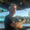 michael saylor założyciel microstrategy wskazujący na monetę bitcoin na tle wykresów giełdowych