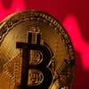 Złota moneta BTC, z czerwoną strzałą i tłem symbolizującym spadki i panikę