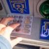 Dłoń wpisująca numer PIN w bankomacie (blokowanie konta).