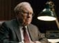 Zamyślony Warren Buffett siedzący przy biurku.