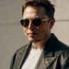 Elon Musk w okularach słonecznych i skórzanej kurtce.
