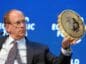 larry fink, ceo blackrock, trzymający monetę bitcoin