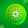 Token Cardano na zielonym tle.