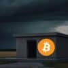 Betonowy schron z logo Bitcoin. W tle czarne chmury.