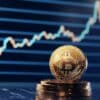 Monety Bitcoin, w tle wykres giełdowy.
