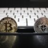 Moneta Bitcoin i moneta Ethereum, w tle klawiatura komputerowa.