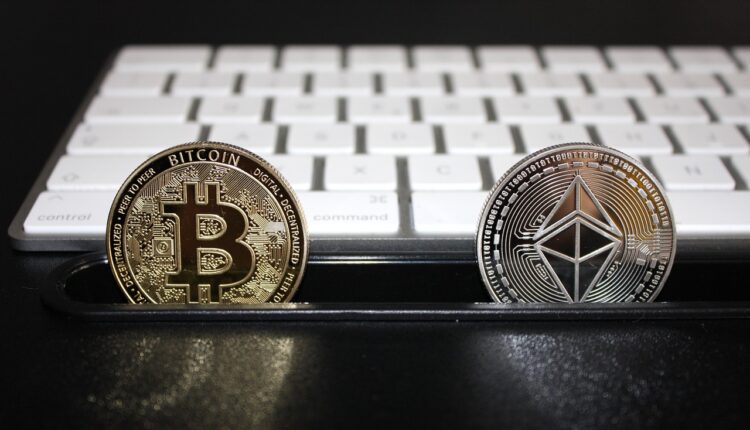 Moneta Bitcoin i moneta Ethereum, w tle klawiatura komputerowa.