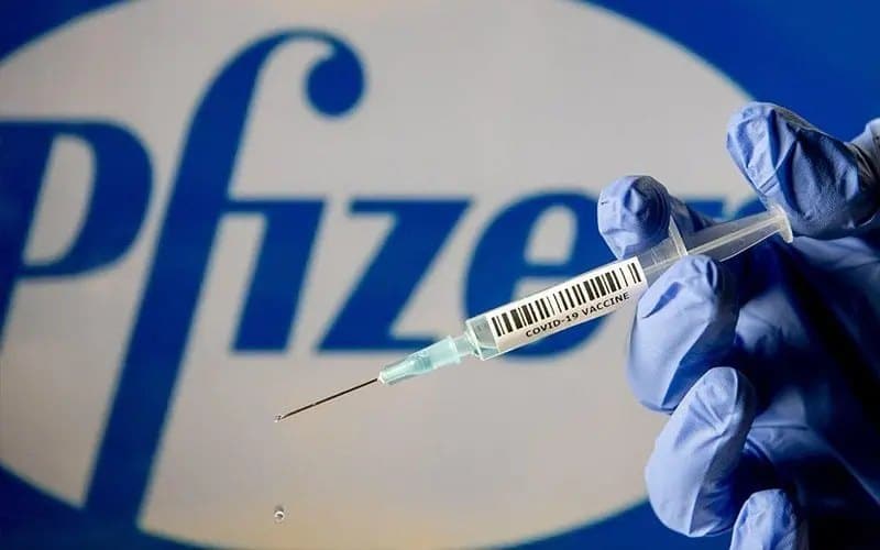 logo firm pfizer, strzykawka na pierwszym planie