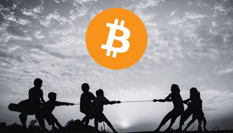 Bitcoin, w tle przeciąganie liny.
