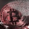 Rozsypująca się moneta Bitcoina.
