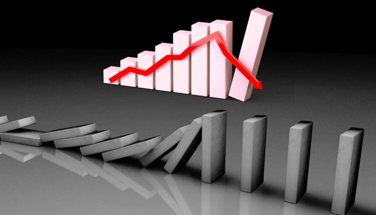 Domino symbolizujące początek krachu, w tle wykres spadku.