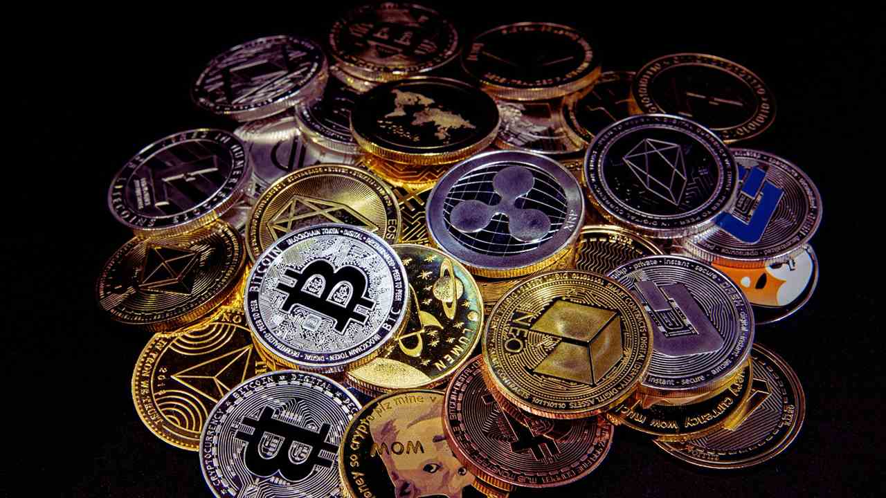 Kryptowaluty w formie fizycznych monet w przyciemnionmy świetle.