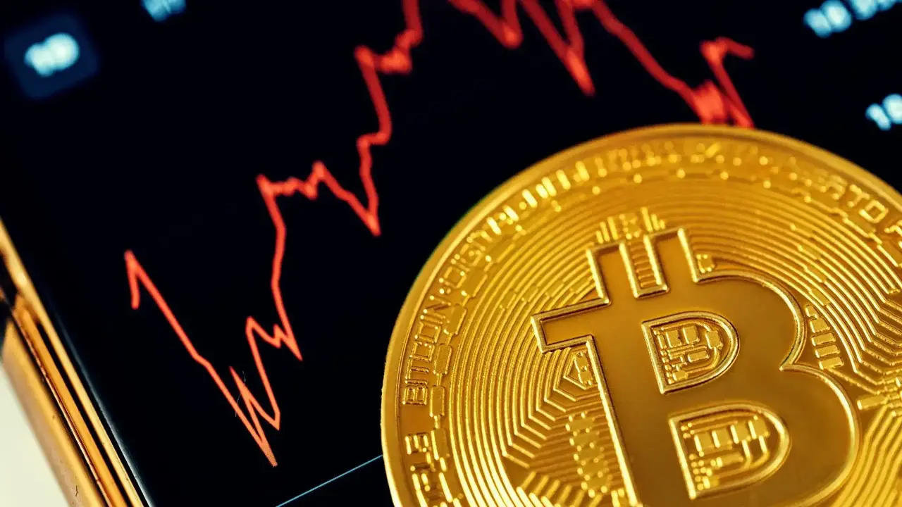 Bitcoin na tle wykresu, który pokazuje spadek.