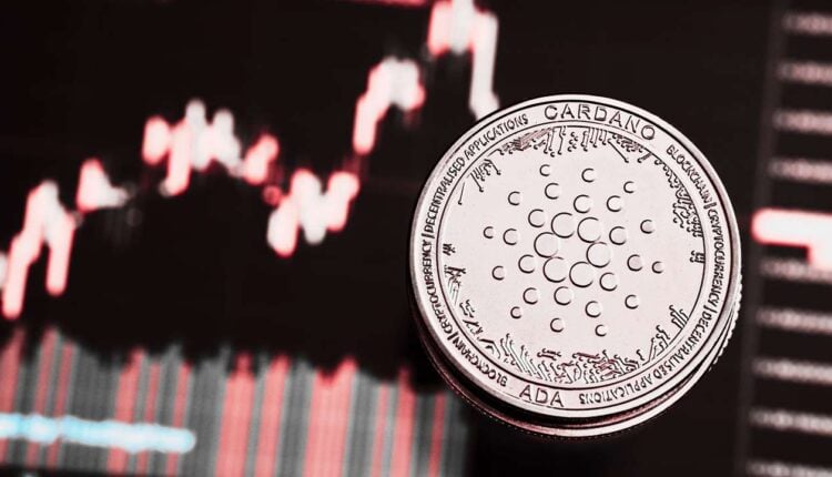 Token Cardano (ADA) na tle wykres giełdowego, który pokazuje spadki.