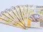 Banknoty 200 zł na jasnym blacie.