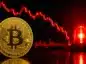 Bitcoin na tle czerwonego wykresu. Sygnał alarmowy.